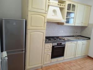a kitchen with white cabinets and a stainless steel refrigerator at Casetta Capanne in Capanne