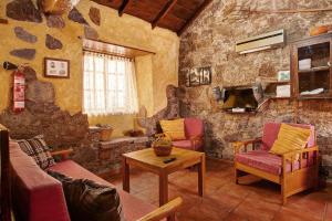 a living room with a couch and chairs and a table at Acogedora Casa Rural en Gran Canaria in La Culata
