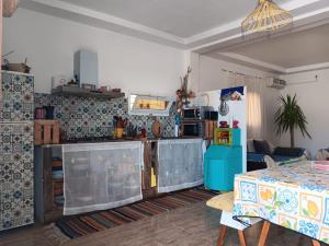 a living room with a kitchen and a table at l' Escapade El Haouaria in Douar Hasni Salah