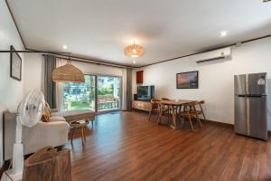ein Wohnzimmer mit einem Tisch und einem Kühlschrank in der Unterkunft V205 Island Hideaway Near Promthep Sunset in Nai Harn Beach