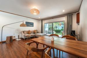 ein Wohnzimmer mit Tisch und Couch in der Unterkunft V205 Island Hideaway Near Promthep Sunset in Nai Harn Beach