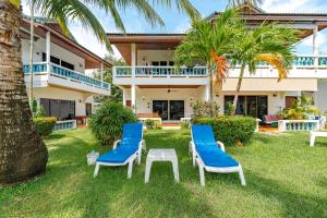 ein Haus mit zwei Stühlen und einem Tisch im Hof in der Unterkunft V205 Island Hideaway Near Promthep Sunset in Nai Harn Beach