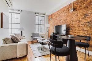 a living room with a brick wall and a table at Blueground Downtown Brooklyn rooftop nr Fort Greene Park NYC-1832 in Brooklyn