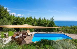 a swimming pool with a large umbrella over it at Casa Silente Opatija by Villas Guide in Lovran