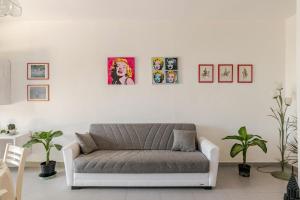 a living room with a couch and pictures on the wall at I Due Gelsi Appartamento White in Monte San Giusto