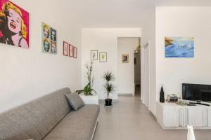 a living room with a couch and a tv at I Due Gelsi Appartamento White in Monte San Giusto +16 photos
