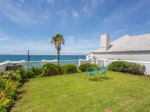 two chairs sitting on a lawn in front of a house at St James Beachfront Villa in St James