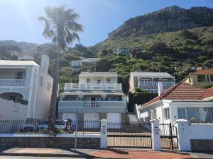 a white house with a fence in front of a mountain at St James Beachfront Villa in St James