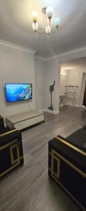 Una sala de estar con un televisor de pantalla plana en una pared. en Newland House, Serviced Accommodation, en Frodingham