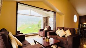 a living room with couches and a large window at Away From Home - 7 - Home Stay Ooty, Entire 3BHK Villa in Ooty