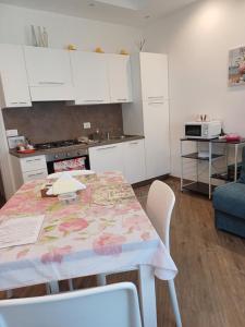 a kitchen with a table and white cabinets at Appartamento Chiara in Roseto degli Abruzzi