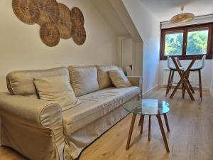 a living room with a couch and a glass table at 15A09 Cueva y Mar Apto con garaje in Nueva de Llanes +15 photos