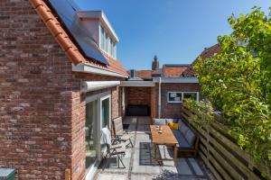 a patio with a table and chairs on a brick building at Vakantiehuis Westkapelle dichtbij strand in centrum in Westkapelle