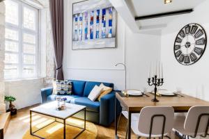 a living room with a blue couch and a table at DeZign Superior Apartments & Rooms in Zadar