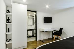 a bedroom with a desk and a bed and a television at DeZign Superior Apartments & Rooms in Zadar