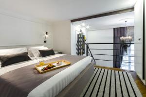 a hotel room with a tray of food on a bed at DeZign Superior Apartments & Rooms in Zadar