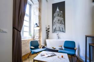 - un salon avec deux chaises bleues et une table dans l'établissement DeZign Superior Apartments & Rooms, à Zadar