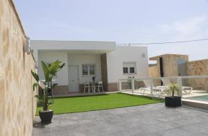 a balcony with green grass and a house at Casa el rincon de la Rosa II in Conil de la Frontera