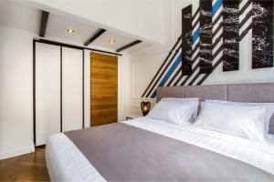 a bedroom with a large bed with white sheets at DeZign Superior Apartments & Rooms in Zadar