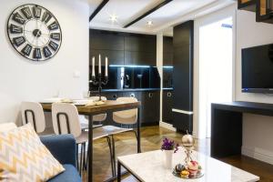 a kitchen and living room with a table and a clock at DeZign Superior Apartments & Rooms in Zadar