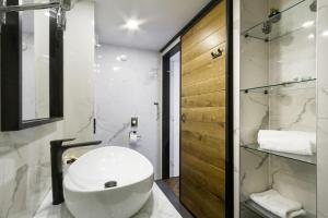 a bathroom with a white sink and a shower at DeZign Superior Apartments & Rooms in Zadar