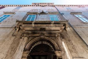 a building with an archway in front of it at DeZign Superior Apartments & Rooms in Zadar