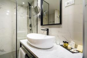 a white bathroom with a sink and a shower at DeZign Superior Apartments & Rooms in Zadar