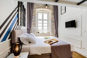 a bedroom with a bed with a tray on it at DeZign Superior Apartments & Rooms in Zadar