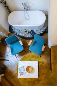 a bathroom with a tub and two chairs and a table at DeZign Superior Apartments & Rooms in Zadar