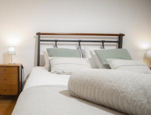 a bedroom with two beds with white pillows at Slowing Villas - Villa Oceano in Porto Santo