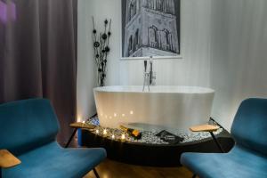 a bath tub in a room with two blue chairs at DeZign Superior Apartments & Rooms in Zadar