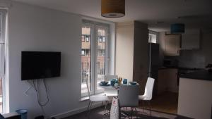 a living room with a table and chairs and a television at 3 BedRoom Ensuite Apartment 100 Apartment Leicester Min 2 weeks in Leicester
