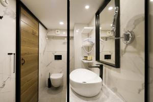 two images of a bathroom with a toilet and a shower at DeZign Superior Apartments & Rooms in Zadar