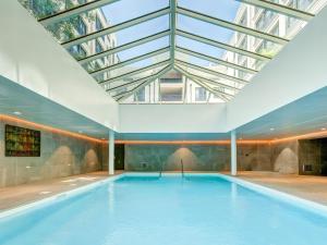 an indoor swimming pool with a glass ceiling at Zenitude Hôtel-Résidences Val d'Europe in Chessy