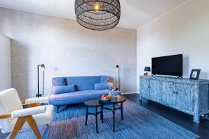 a living room with a blue couch and a tv at Hotel Pannenkoekhuis Vierwegen in Domburg