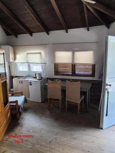 a kitchen with a table and chairs in a room at Wooden house in Keramoti +7 photos