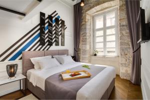 a bedroom with a large bed with a tray on it at DeZign Superior Apartments & Rooms in Zadar