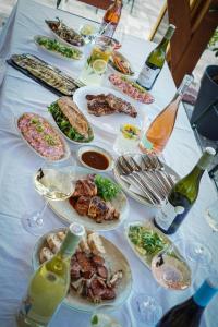 a table with plates of food and bottles of wine at Pinot Gris House in Káptalantóti +10 photos