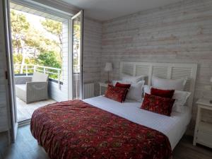 a bedroom with a large bed and a balcony at La Villa Bel Ange Hotel in Saint-Philibert