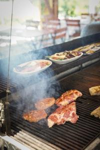 a grill with plates of meat and food on it at Pinot Gris House in Káptalantóti