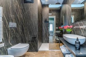 a bathroom with a white toilet and a sink at Puglialux in Bari