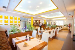 a restaurant with white tables and white chairs at Apartments Vila Kristina in Ba&scaron;ka Voda