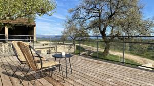 Una terraza de madera con una mesa y sillas en un balcón. en Domaine Saint Sauveur - 15 pers, en Chantemerle-les-Blés