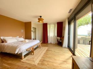 Un dormitorio con una cama con un gato acostado en ella. en Domaine Saint Sauveur - 15 pers, en Chantemerle-les-Blés