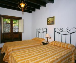 Un dormitorio con dos camas y una ventana. en Finca La Crucita - Ye, en Haría