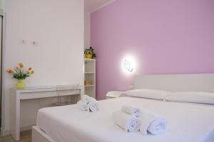 una camera da letto bianca con due letti con asciugamani di RainbHome Colourful Roman Suites a Roma Altre 67 foto