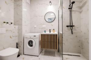 a bathroom with a washing machine and a shower at ShortStayPoland Sokratesa in Warsaw