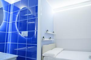 una stanza piastrellata blu con un letto e un tavolo di RainbHome Colourful Roman Suites a Roma