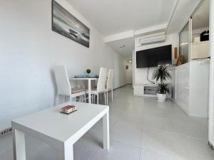 a living room with a white table and chairs at Beachfront apartment in La Mata in La Mata