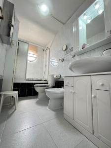 a white bathroom with a sink and a toilet at Beachfront apartment in La Mata in La Mata +10 photos